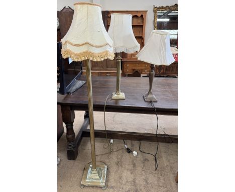 A brass standard lamp together with two brass table lamps