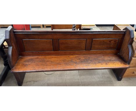 A pine church pew with shaped ends and a three panelled back, 180cm long