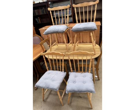A modern oak kitchen dining table together with a set of four stick back chairs and another pair of chairs