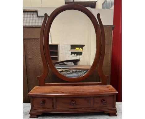A reproduction mahogany toilet mirror with an oval mirror, the base with three drawers on bracket feet