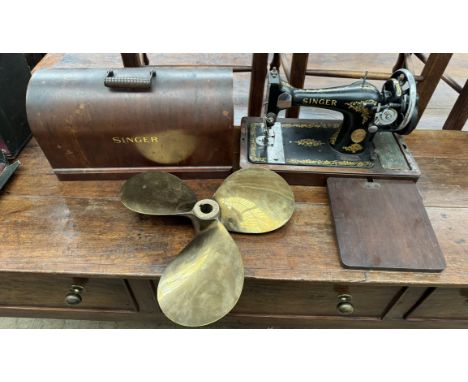 A brass propeller together with a cased Singer sewing machine  