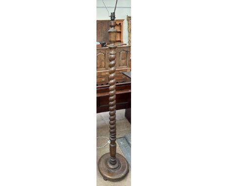 An oak standard lamp with a barley twist column on a turned base 