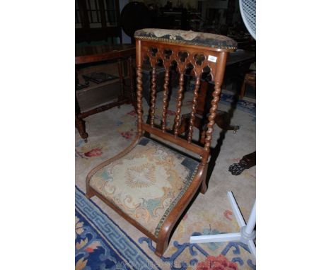 A Mahogany framed Prie Dieu Chair, having six mirrored twist back supports, brass studded tapestry seat, top rail with religi