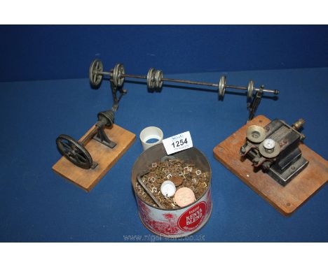 Two engine parts, wheels and tin of nuts.