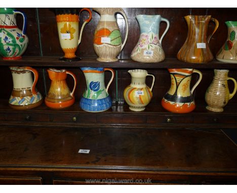 Six colourful Myott Jugs, various patterns including orange, yellow and grey striped jug with black handle, etc.