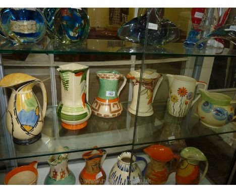 Six colourful Myott Jugs, various patterns including daisy, leaves, etc.