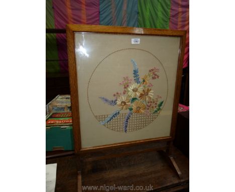 A mid Oak framed firescreen having needlework floral design, 29" high and 21 1/2" wide.
