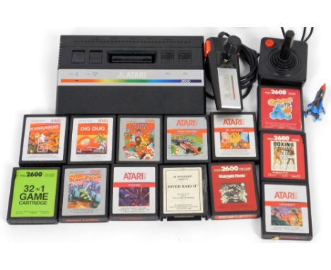 An original Atari 2600 games console, 26cm W with some wires and cartridges to include Q-bert, etc. (a quantity) 