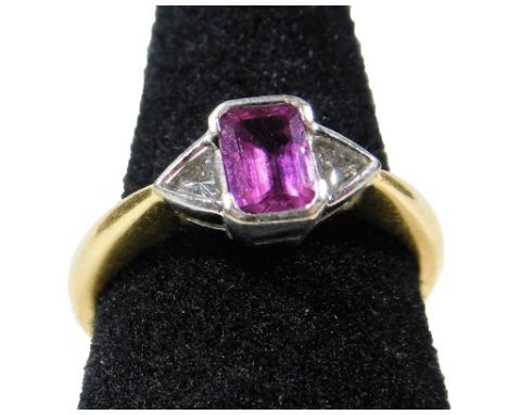 An 18ct gold ruby and diamond dress ring, with central rectangular cut pale red/pink ruby measuring 5.8mm x 4.2mm x 2.4mm, to