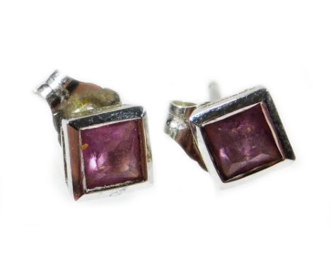 A pair of 18ct white gold ruby stud earrings, each stone square cut and pale pink in colour, measuring 3.4mm x 1.8mm, in rub 