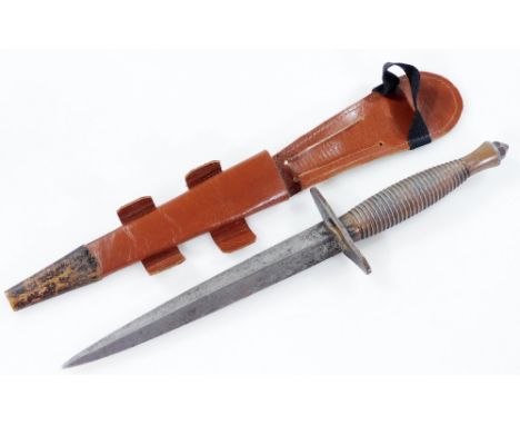 A Fairbairn Sykes Commando knife, turned handle and leather scabbard, 28cm W.