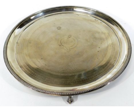 An early 20thC silver plated tray, by Mappin and Webb, of circular form with a bead outline and part engine centre, on claw f