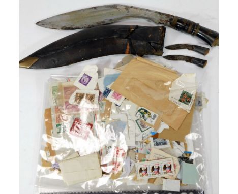 An early 20thC Gurkha kukri with leather scabbard, with a turned handle and shaped blade, 43cm H, with miniature knives and v