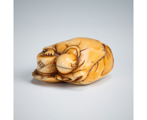 AN OLD IVORY NETSUKE OF A TEA GRINDER NAPPING BESIDE A MILLSTONEUnsignedJapan, 18th century, Edo period (1615-1868)The fatigu