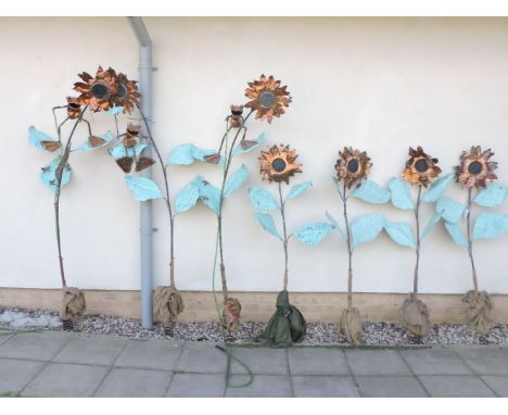 A group of hand made sunflowers, upon a sprung and weighted base, beaten and polished copper flowers with green copper leaves