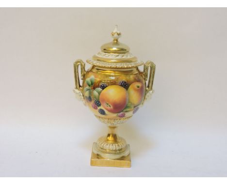 A Royal Worcester porcelain urn, with turned knop and classical mask handles to either side, decorated with hand painted frui