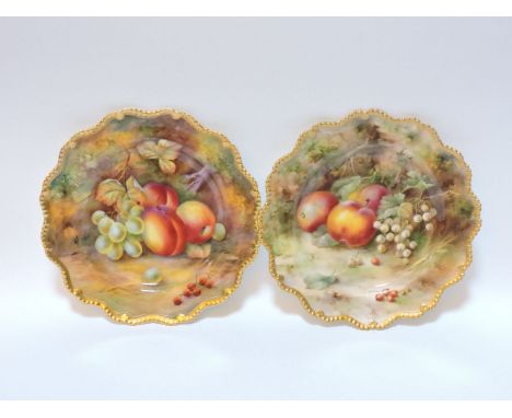 A pair of Royal Worcester cabinet plates, with lobed edges, decorated with hand painted fruit, upon a mossy bank, one signed 