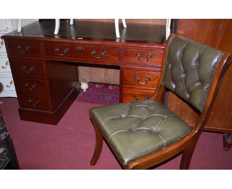 A reproduction mahogany and gilt tooled green leather inset twin pedestal writing desk, together with green leather button ba