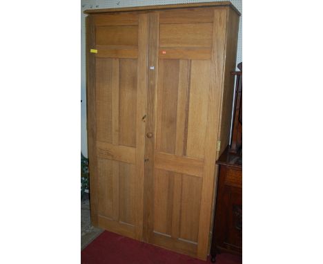 A large early 20th century light oak double door panelled larder cupboard, the interior with fitted shelves