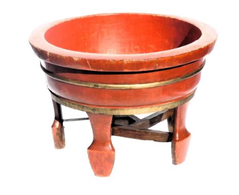 A Chinese red and gilt lacquer circular barrel planter, raised on five feet united by stretchers, 54cm wide.
