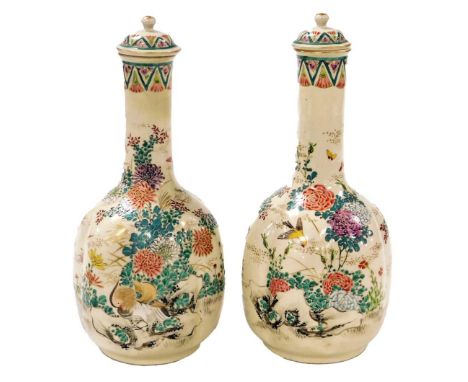 A pair of Meiji period Japanese Satsuma bottle vases and covers, of lobed form, enamel decorated with birds and flowers, 24cm