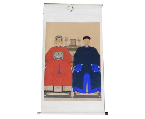 A Chinese ceremonial ancestor portrait scroll,  depicting two family members in front of a table bearing a mirror and pair of