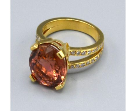 An 18ct Gold Morganite and Diamond Ring with a large oval Morganite claw set and double diamond band shoulders 9.9grams, ring