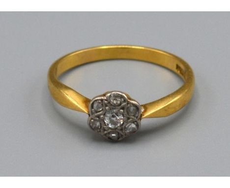 A 18ct Yellow Gold Diamond Cluster Ring set with seven diamonds within a pierced setting, Size M, 2.3 grams 