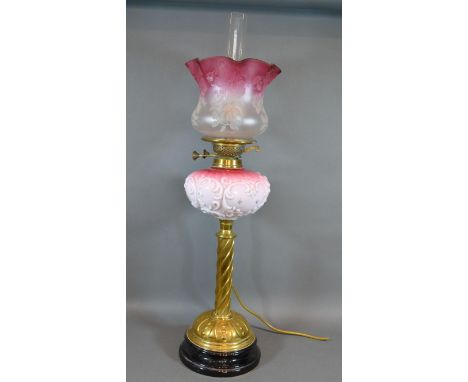 A Victorian Brass and Glass Oil Lamp with brass column and cranberry glass and opaque shade and bowl, converted to electricit