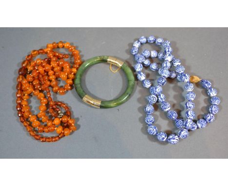 A Jade Bangle together with an Amber Bead Necklace and another Bead Necklace 