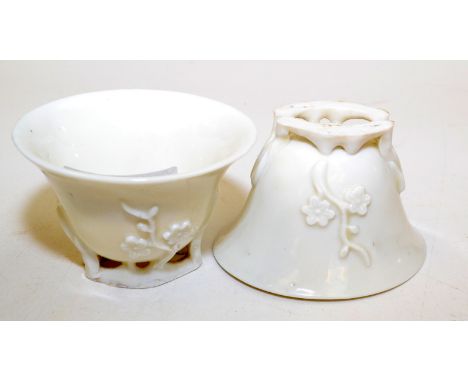 A pair of 18th century Chinese blanc de chine, oval libation cups, each moulded with flowering branches on naturalistic feet 