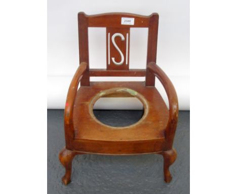 A Victorian child's open arm, commode chair on cabriole legs.