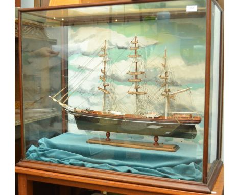 A wooden scale 1:100 model of The Cutty Sark, length 75cm, in a glazed case width 92cm. 
