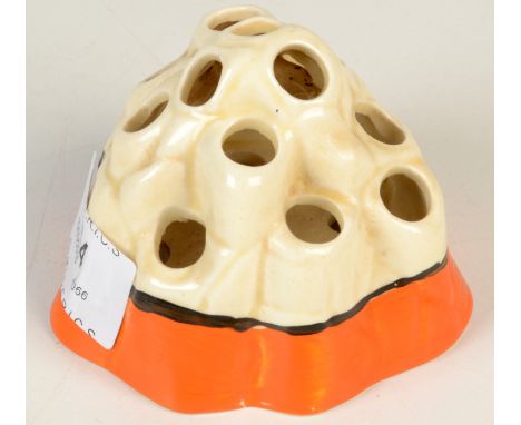 A Clarice Cliff flower spreader No.225 moulded as a craggy rock, the base with an orange band, height 6.5cm.