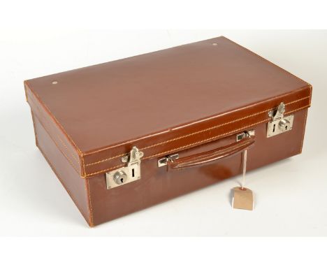 A gentleman's brown leather travelling case, the fitted interior with toilet jars and ebony brushes, together with a spirit f