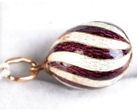 A Russian ivory and amethyst enamelled egg, height 1.6cm. Condition Report: Good. Mark is 563-960 and star with hammer & sick