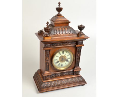 A continental carved walnut mantle clock, height 48cm. Condition Report: One finial damaged. 