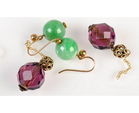 A pair of jade earrings and a pair of amethyst earrings. 
