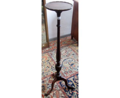 A turned mahogany plant stand on a tripod base.
