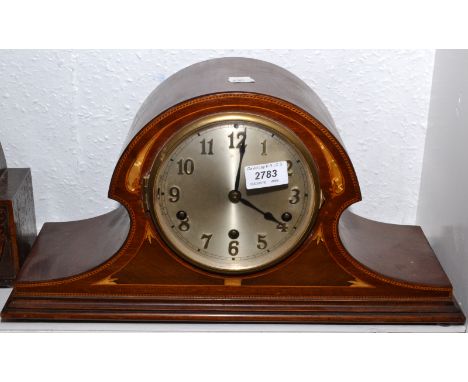 A mantle clock with Westminster chime in an arched, inlaid mahogany case. 