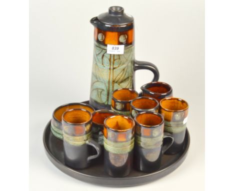 A Celtic Pottery, Newlyn 'Medallion' pattern coffee set comprising a coffee pot, six coffee cans, a milk jug, two sugar bowls