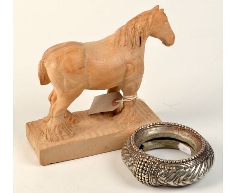 An African silver coloured metal bangle and a carved wood model of a horse. 