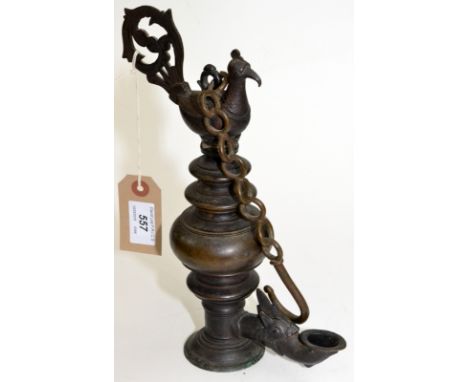 A Burmese bronze oil lamp with a chain hanger and peacock mount, the burner cast with the head of a dragon, height 27cm (dama