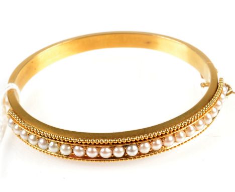 A good Victorian matte gold bangle, half of the hoop is set with pearls in a gold bead border, original box of  'Barraclough'