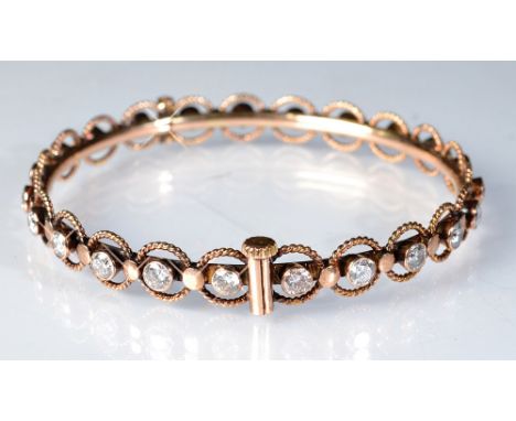 A 14ct. gold bangle set with twenty three round, brilliant cut diamonds, approximately 0.15ct. each, overall diamond weight 3
