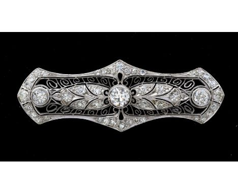 An Edwardian diamond and platinum brooch, comprising an elongated pierced form, with leaf decoration mille grain set diamonds