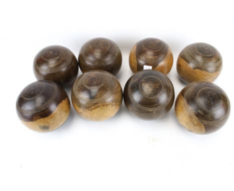 A set of eight vintage lignum vitae carpet bowls. With carved details, Diameter 11.5cm