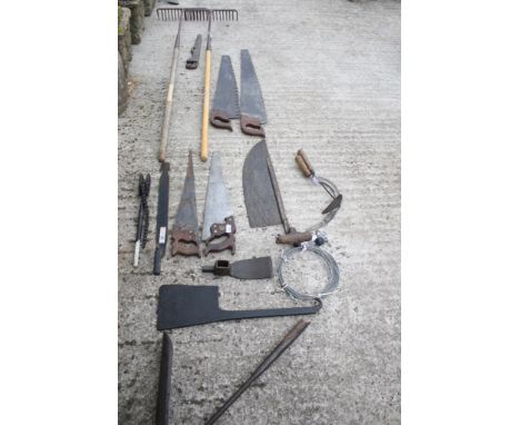 A collection of assorted vintage tools. Including carpenters' saws and garden rakes, etc. 