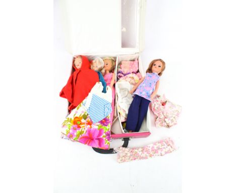 Four vintage Sindy dolls. Of various designs, together with a range of clothing, tontained within a pink 'Sindy' case with a 
