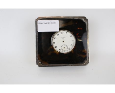 A travelling clock in a silver and tortoise shell case. 8-day, 'Walker &amp; Hall Ltd' Swiss made movement, white enamel dial